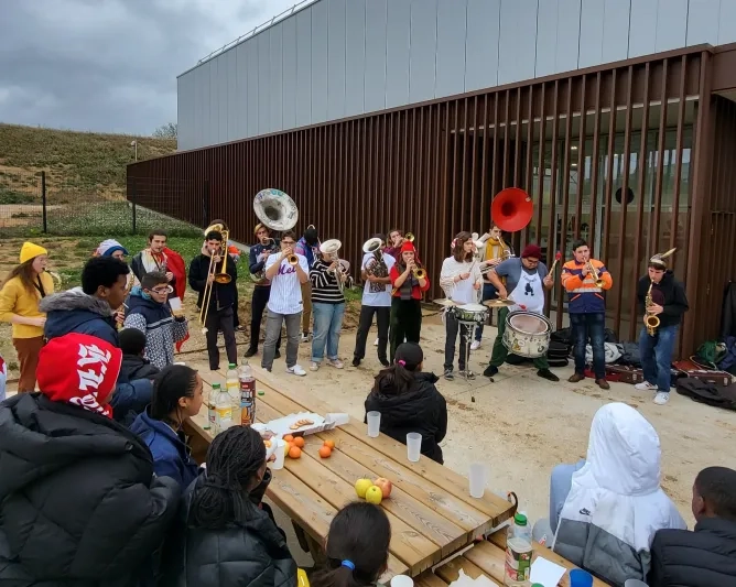 Groupe de tutorés devant le gymnase regardant la fanfare de l'école